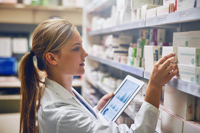 Pharmacist looking up prescription data on a tablet using Bamboo Health's NarxCare technology