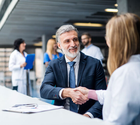 Doctor speaking to and shaking hands with a healthcare executive