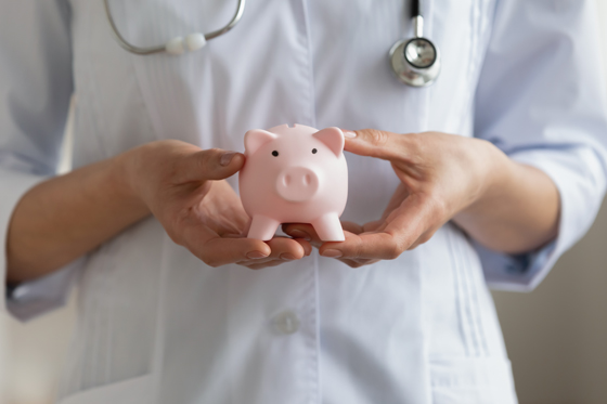 Close up of female doctor holding a piggybank