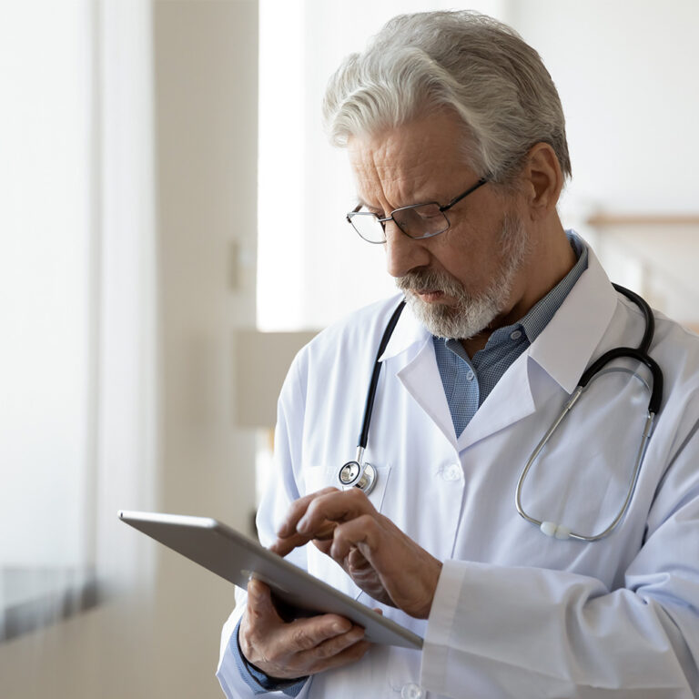 Mature male doctor using a tablet
