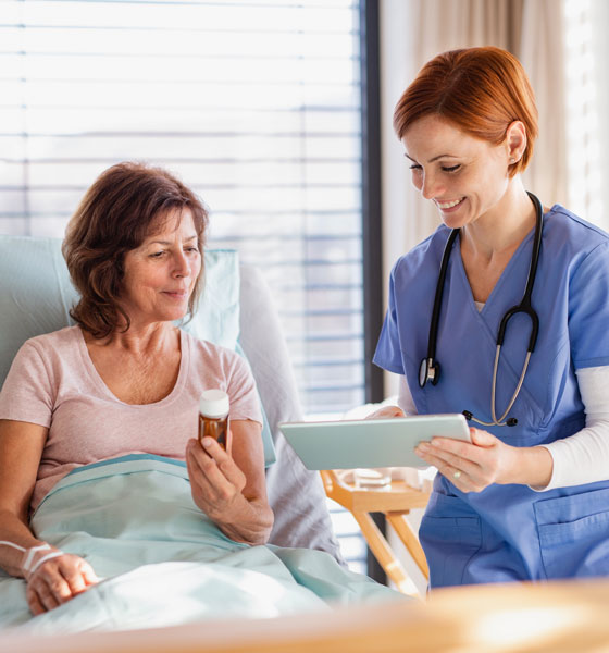 Female Doctor holding tablet and talking to a female patient